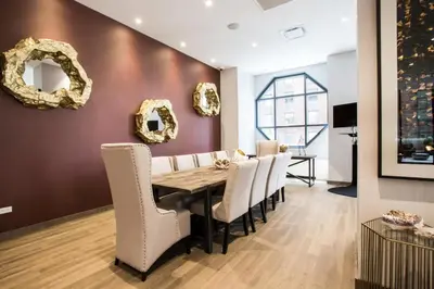 a dining room with a table and white chairs at Modern Bright Times Sq 1BR w Indoor pool NYC-8 in New York