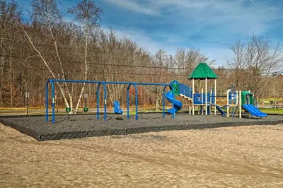a park with a playground with a slide at Deck and Community Perks Bright Pocono Lake Home! in Pocono Lake