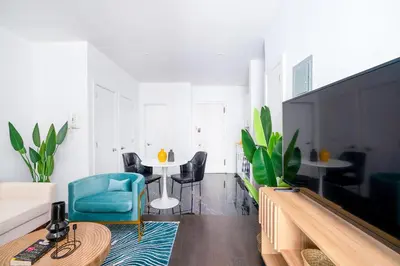 a living room with a table and a blue chair at 444-4F Newly renovated 1BR in Midtown West in New York