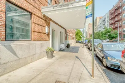 an umbrella on a sidewalk in front of a building at Upper W Side 1BR w Gym by Lincoln Sq NYC-331 in New York