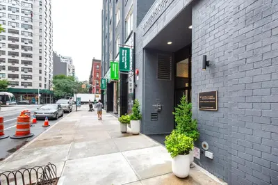 a sidewalk with potted plants in front of a building at East Village 2br w doorman wd nr Union Square NYC-1185 in New York