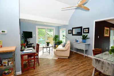 a living room with blue walls and a ceiling fan at Luxury Cottage at Millpond Falls in Warwick