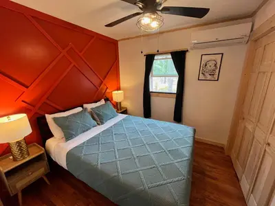 a bedroom with a blue bed with an orange wall at Wally's Cabin in Hawley