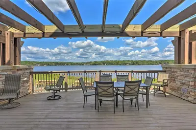 a deck with a table and chairs and a view of a lake at Walk to Beaches Tree-Lined Pocono Lake Retreat! in Pocono Lake