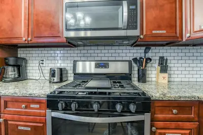 a kitchen with a stove and a microwave at TWO Modern Apartment Minutes to NYC in Jersey City