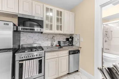 a kitchen with white cabinets and a stove top oven at Charming 2Bd in Brooklyn Heights in Brooklyn