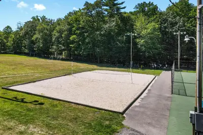 a tennis court with a net in a park at Brentwood Burrow in East Stroudsburg