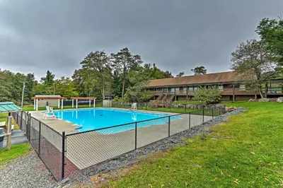 a fence around a swimming pool in a yard at 5 Mi to Tobyhanna State Park Home with Game Room! in Tobyhanna