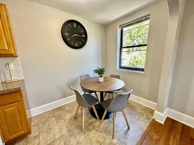 a dining room with a table and a clock on the wall at Lennox C407 Cozy and Spacious Studio1br Apt in Philadelphia