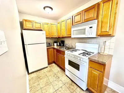 a kitchen with white appliances and wooden cabinets at Lennox C407 Cozy and Spacious Studio1br Apt in Philadelphia