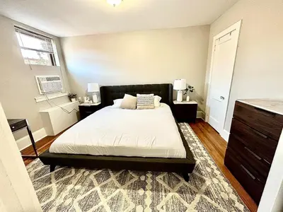 a bedroom with a bed and two tables and a window at Lennox C304 Peaceful & Perfect Private 1-br in Philadelphia