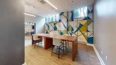 a conference room with a table and chairs and a mosaic wall at Avenue A310 Furnished 2br With Pool And Gym in Philadelphia