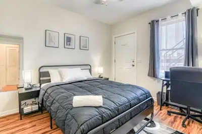 a bedroom with a bed and a desk and a window at Modern 3BR2BA Apartment Minutes to NYC in Jersey City
