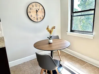 a dining room with a table and a clock on the wall at Lennox B405 Peaceful & Perfect Studio Apt in Philadelphia