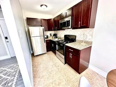 a kitchen with wooden cabinets and a white refrigerator at Lennox B405 Peaceful & Perfect Studio Apt in Philadelphia