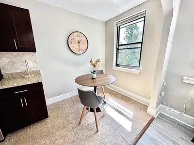 a kitchen with a table and a clock on the wall at Lennox B401 Peaceful & Perfect Studio Apt in Philadelphia