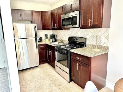 a kitchen with wooden cabinets and stainless steel appliances at Lennox B401 Peaceful & Perfect Studio Apt in Philadelphia