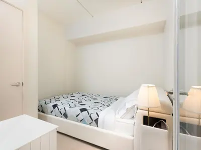 a white bedroom with a bed and a mirror at Pet Friendly 2 Bedroom and 2 Bathroom Apartment near Rittenhouse apts in Philadelphia