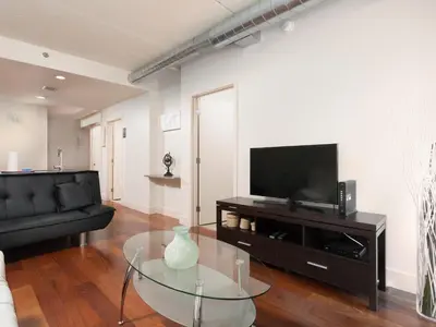 a living room with a glass table and a television at Cozy Fully Furnished 2 Bedroom 2 Bathroom Apartment apts in Philadelphia