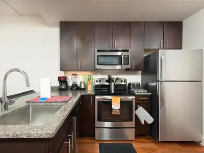 a kitchen with stainless steel appliances and wooden cabinets at Cozy Fully Furnished 2 Bedroom 2 Bathroom Apartment apts in Philadelphia