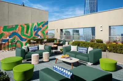 a patio with green couches and tables and a mural at Financial District 1br w WD gym elevator NYC-1362 in New York