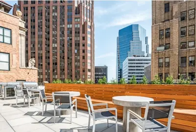 a rooftop patio with tables and chairs and a city skyline at FiDi jr 1br w game room resident-only bar NYC-1336 in New York