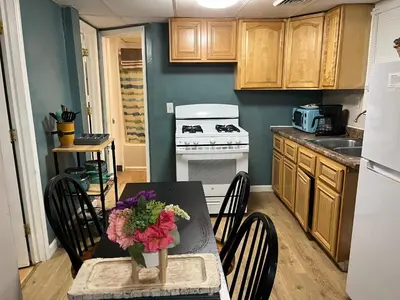 a kitchen with a table with flowers on it at Cozy Apt near BU, Lourdes, UHS in Johnson City
