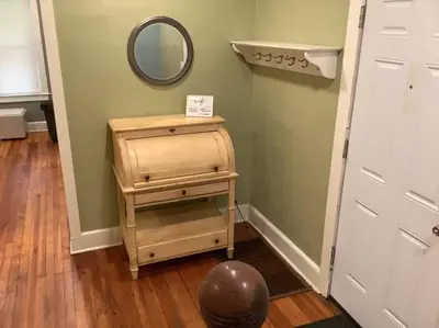 a small wooden dresser with a mirror next to a door at Spacious Inviting Home by BU UHS & Guthrie in Johnson City