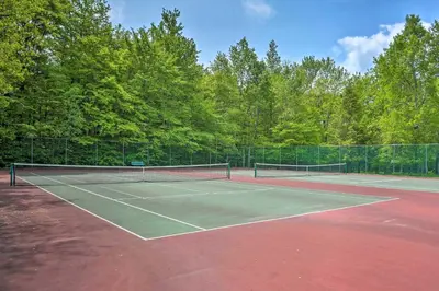 a tennis court with two tennis rackets on it at 1 Mi to Beach Pocono Lake Chalet with Decks in Pocono Lake
