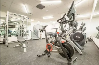 a gym with two exercise bikes and a treadmill at Luxury 2BD nr Wall St Gym Rooftop w/d in New York