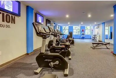 a gym with rows of exercise bikes in a room at XL Studio - Modern Studio with Rooftop Pool in Philadelphia