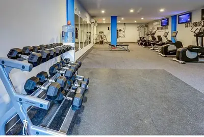 a gym with rows of treadmills and machines at XL Studio - Chic Flat - Rooftop Pool & Gym in Philadelphia