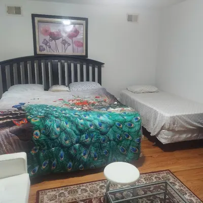 a bedroom with two beds and a table and chairs at Cosy Bedroom 12mins to Airport Prudential NJIT UMDJ Penn Station in Newark