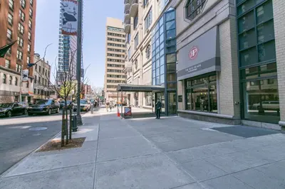 a city street with buildings and a person walking on the sidewalk at Theater District Studio w Indoor pool NYC-142 in New York