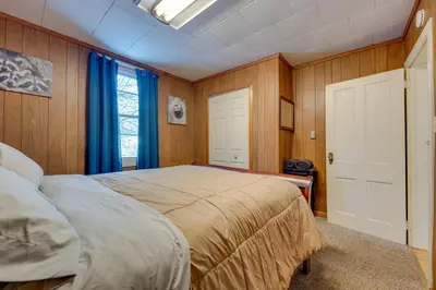 a bedroom with a large bed with blue curtains at Private Hot Tub Poconos Babbling Brooke Cottage in Blakeslee