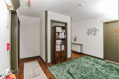 a hallway with a green rug and a book shelf at Charming Studio in Thornton PA in Thornton
