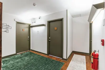 a hallway with two doors and a green rug at Thornton Studio with Kitchenette in Thornton