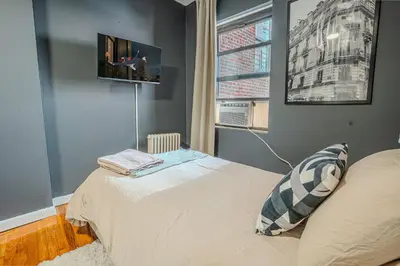 a bedroom with a bed and a tv on the wall at Chic 3Bd NoMad Manhattan in New York