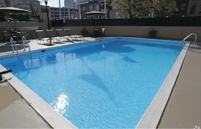 a large blue swimming pool with chairs and tables at PP 1114 Beautiful Professional 1br Apt, Pool in Harrisburg