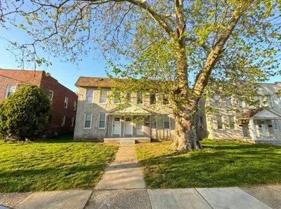a house with a tree in the front yard at Cozy Walk up King Bed fast WiFi in Wilmington