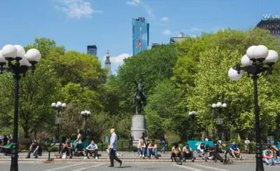 a group of people sitting on benches in a park at Heart of Downtown Manhattan - Stylish One Bedroom Apartment in Vibrant Union Square in New York