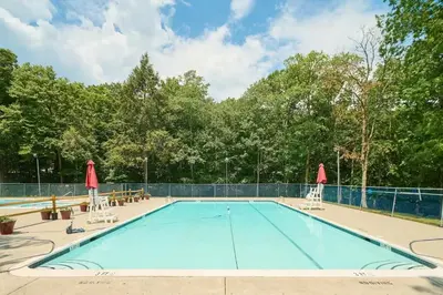 a large swimming pool with two lawn chairs at Wonderful Family Place w/HotTub/Sauna/Billiard/Private Pool in East Stroudsburg