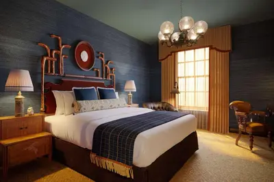 a bedroom with a large bed with blue walls at Graduate by Hilton Princeton in Princeton