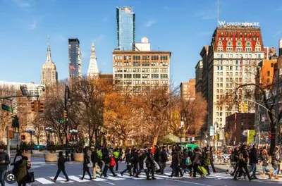 a group of people crossing a street in a city at Private Room at a 3 bedroom Apt at the heart of East Village - shared apartment in New York