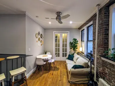 a living room with a couch and a table at Private Room at a shared Apartment at the Heart of East Village in New York