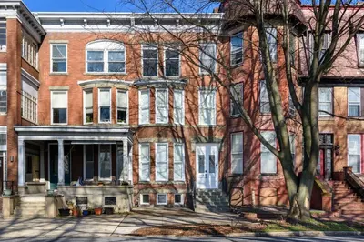 a large brick building with a tree in front of it at Flats on Front - Riverfront Gem Fast Wi-Fi 1F in Harrisburg