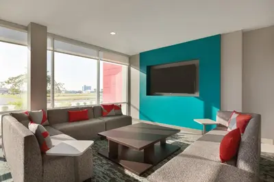 a living room with a couch and a tv on a wall at avid hotel Harrisburg NE - Hershey Area by IHG in Harrisburg