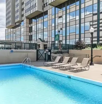 a swimming pool with lounge chairs and a building at PP 1009 Beautiful Corporate 2br Apt, Pool in Harrisburg
