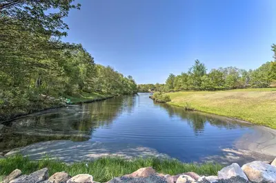 a river with rocks and trees on the side at Lakefront Long Pond Home with Wraparound Deck! in Long Pond