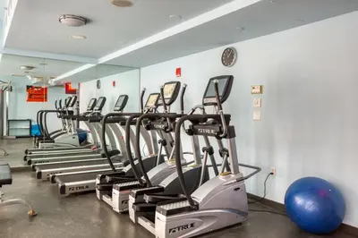 a row of exercise bikes lined up in a gym at Midtown West 1br w gym wd nr bryant park NYC-1380 in New York